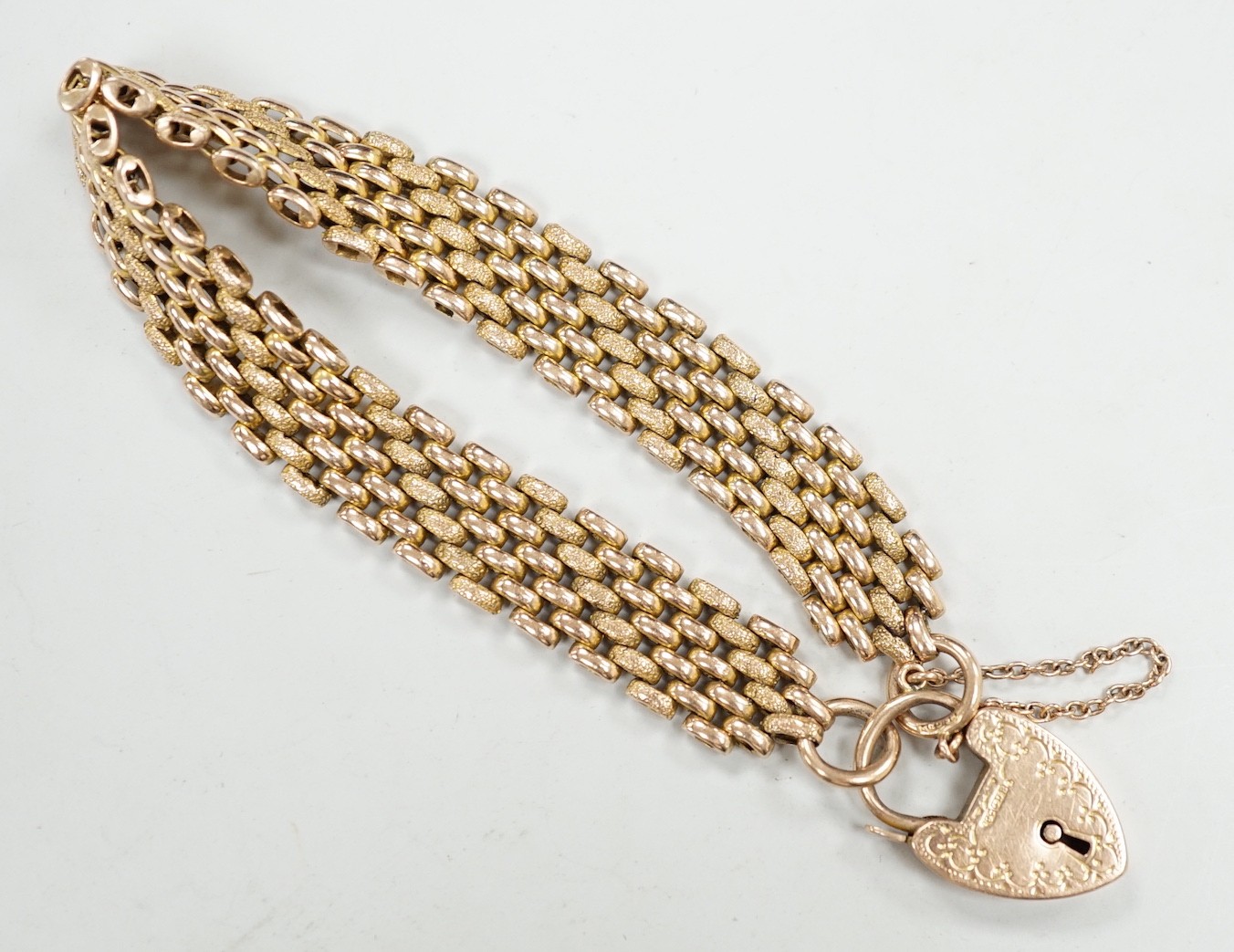 An early 20th century yellow metal (stamped 9c) gate link bracelet, with heart shaped padlock clasp, 18cm, 24.7 grams.